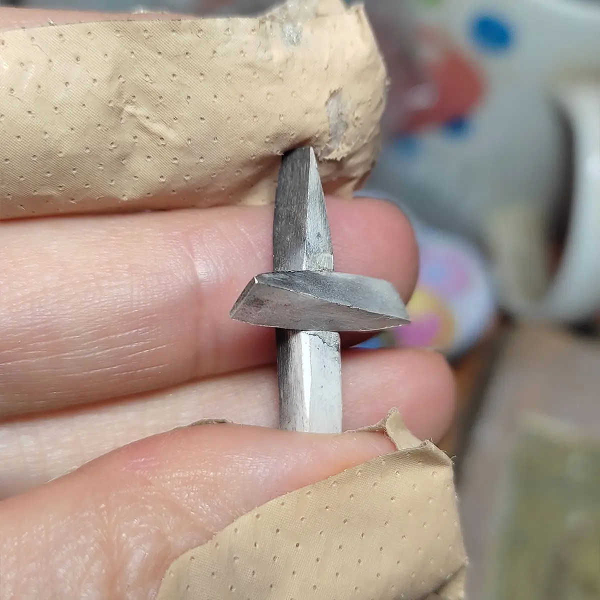 Detalle del diseño tridimensional e intrincado en cruz artesanal de plata 950